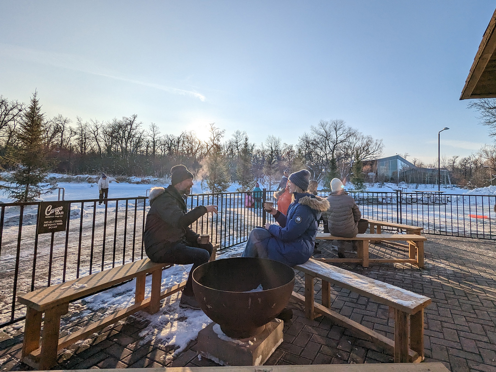 small group of people sitting around an outdoor winter firepit